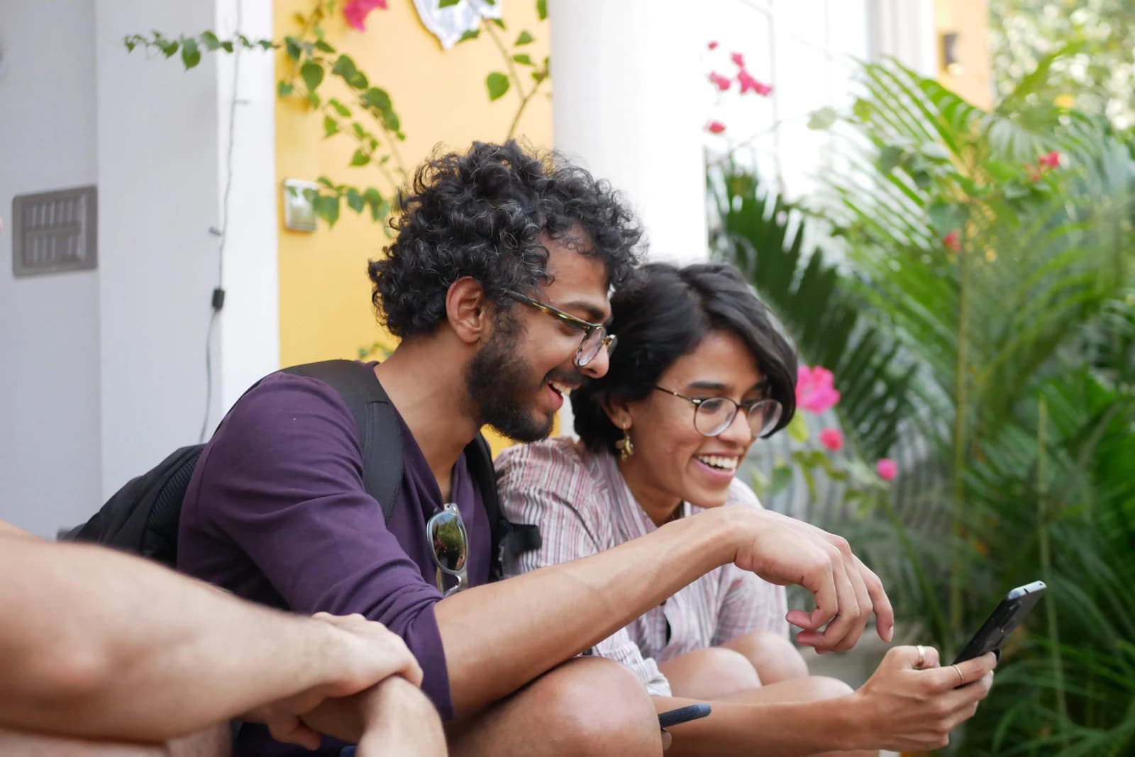 Two people laughing at something on a phone