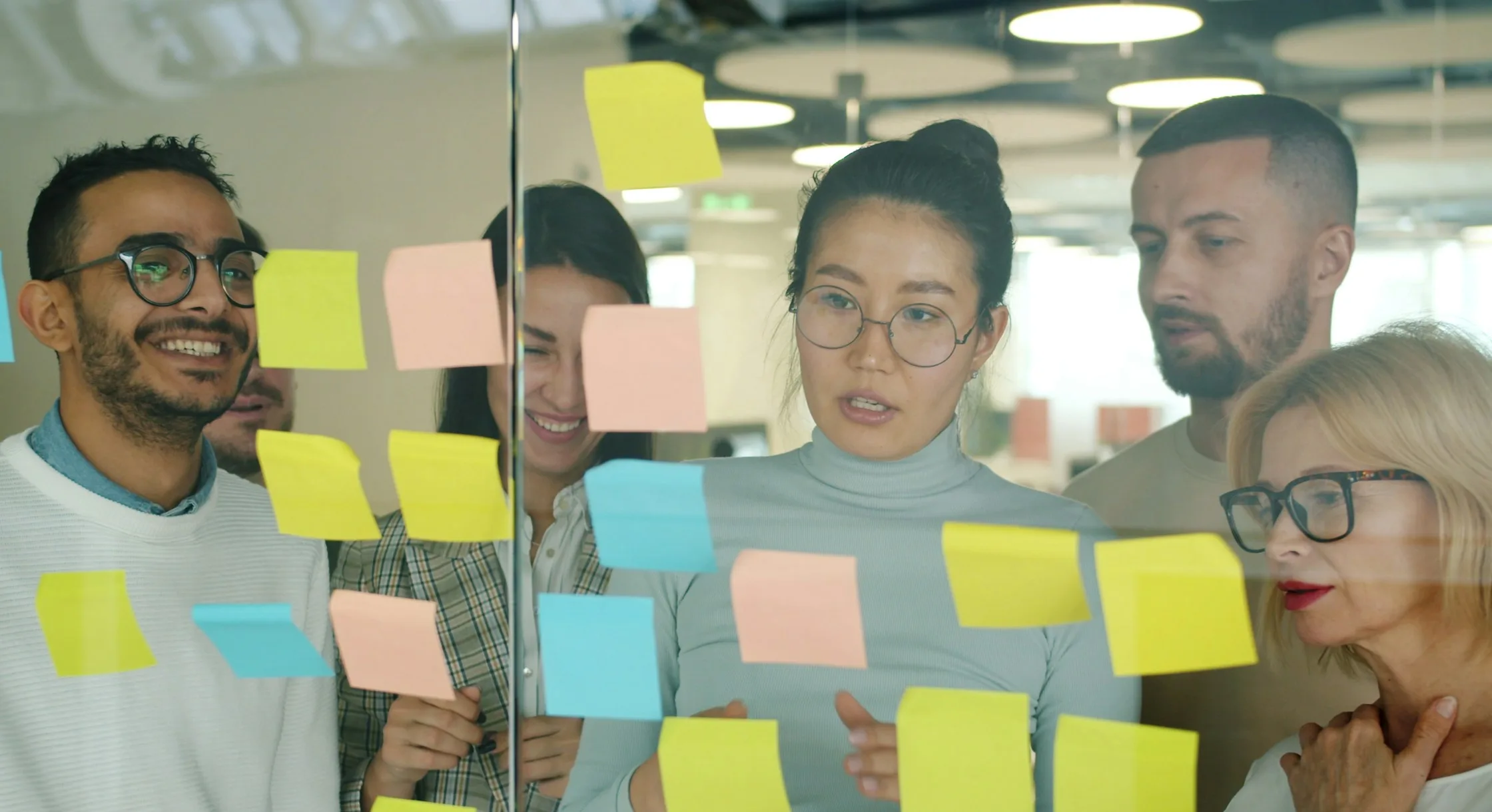 Colleagues planning together at a wall of sticky notes