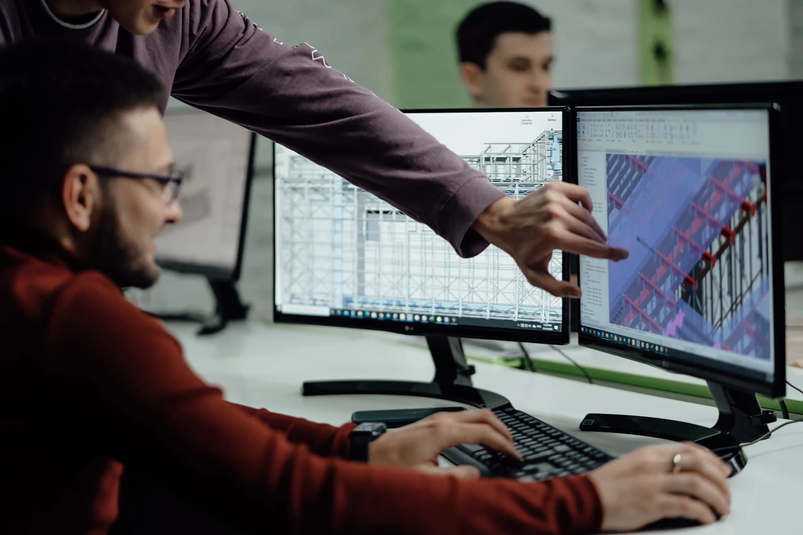 A colleague pointing out a detail on a data scientist's screen